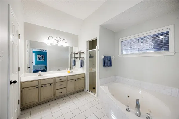 a bathroom with a tub a sink and mirror