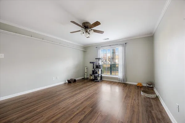 a view of a room with wooden floor and ceiling fan