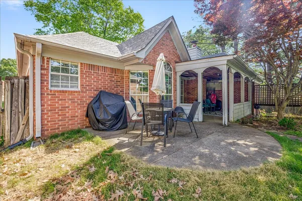 a front view of a house with a garden and trees