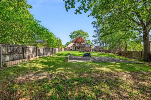 a view of a house with a yard and tree s