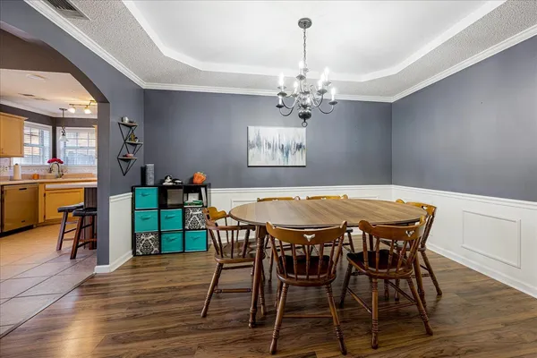 a view of a dining room with furniture wooden floor and chandelier