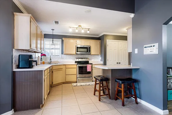 a kitchen with stainless steel appliances kitchen island granite countertop a stove top oven a sink a dining table and chairs