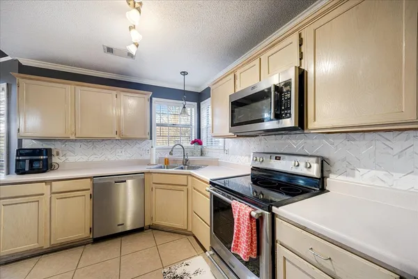 a kitchen with stainless steel appliances a stove sink microwave and cabinets