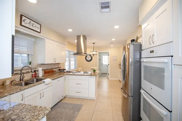 a kitchen with stainless steel appliances granite countertop a refrigerator and a sink