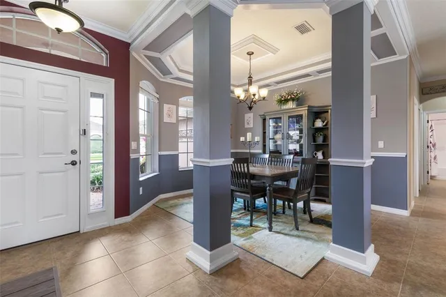 a dining room with furniture water view and a floor to ceiling window