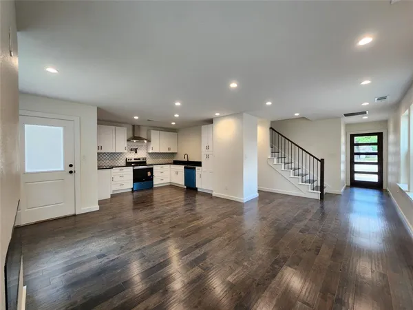 a view of kitchen with kitchen island wooden floor appliances and center island