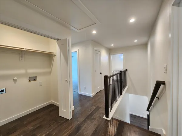 a view of a hallway with wooden floor and stairs