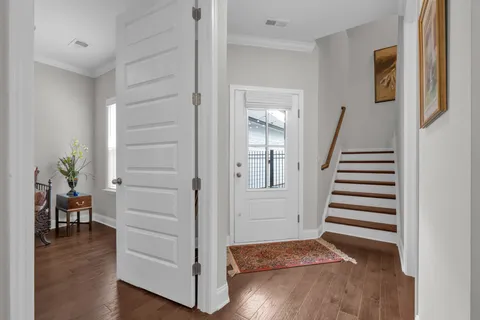 a view of a hallway with wooden floor and stairs