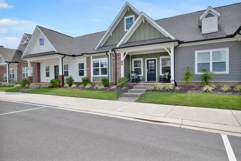 front view of a brick house with a yard