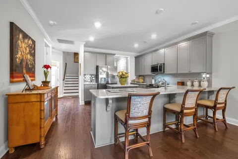 a kitchen with stainless steel appliances granite countertop dining table chairs refrigerator and sink