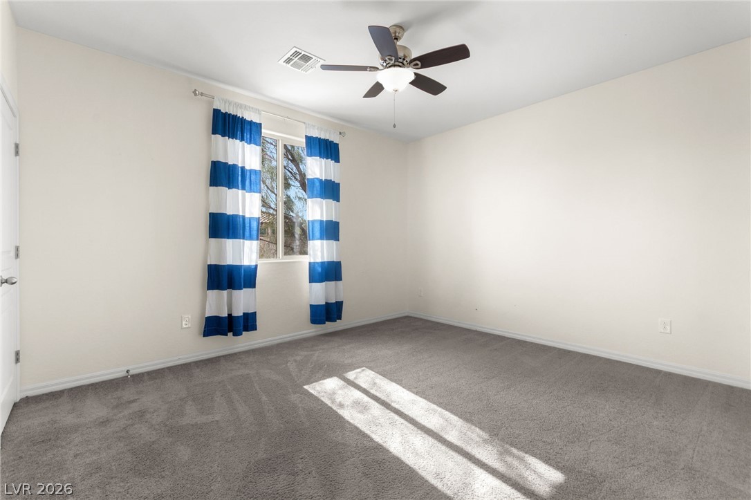 11048 Prairie Grove Road Las Vegas, NV 89179 - Photo 51 of 75 Sun-filled room with plush carpeting and a modern ceiling fan.