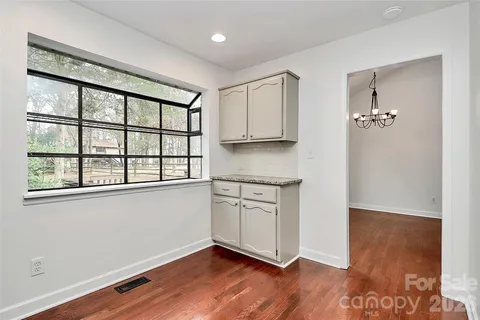 a view of a kitchen with wooden floor and a window