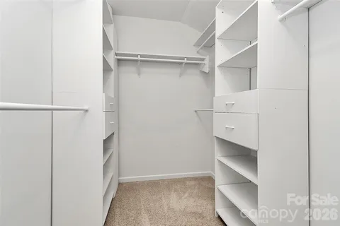 a view of walk in closet with empty racks