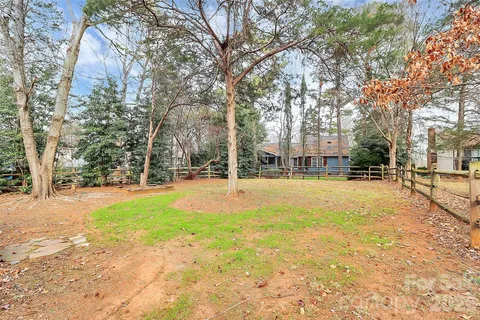 a view of a house with a yard and wooden fence