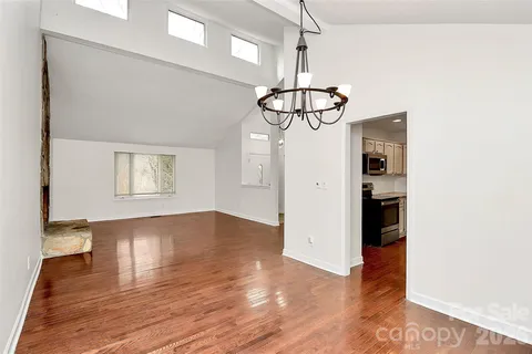 a view of empty room with wooden floor and ceiling fan