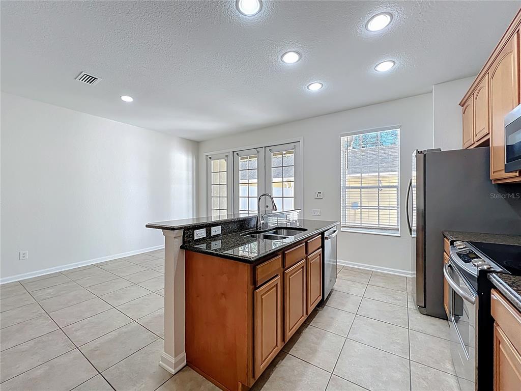 12930 Vennetta Way Windermere, FL 34786 - Photo 8 of 38 a kitchen with stainless steel appliances granite countertop a stove a sink and a refrigerator