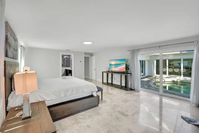 a spacious bedroom with a large bed and a large window