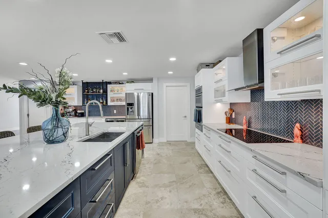 a kitchen with stainless steel appliances granite countertop a sink a stove and a wooden cabinets