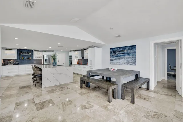 a living room with furniture a table and kitchen view