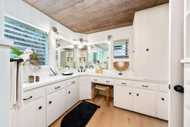 a kitchen with white cabinets and sink