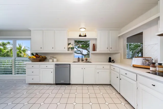 a kitchen with a white cabinets and window