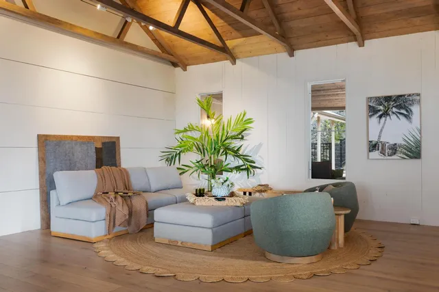 a living room with furniture flowerpot and wooden floor