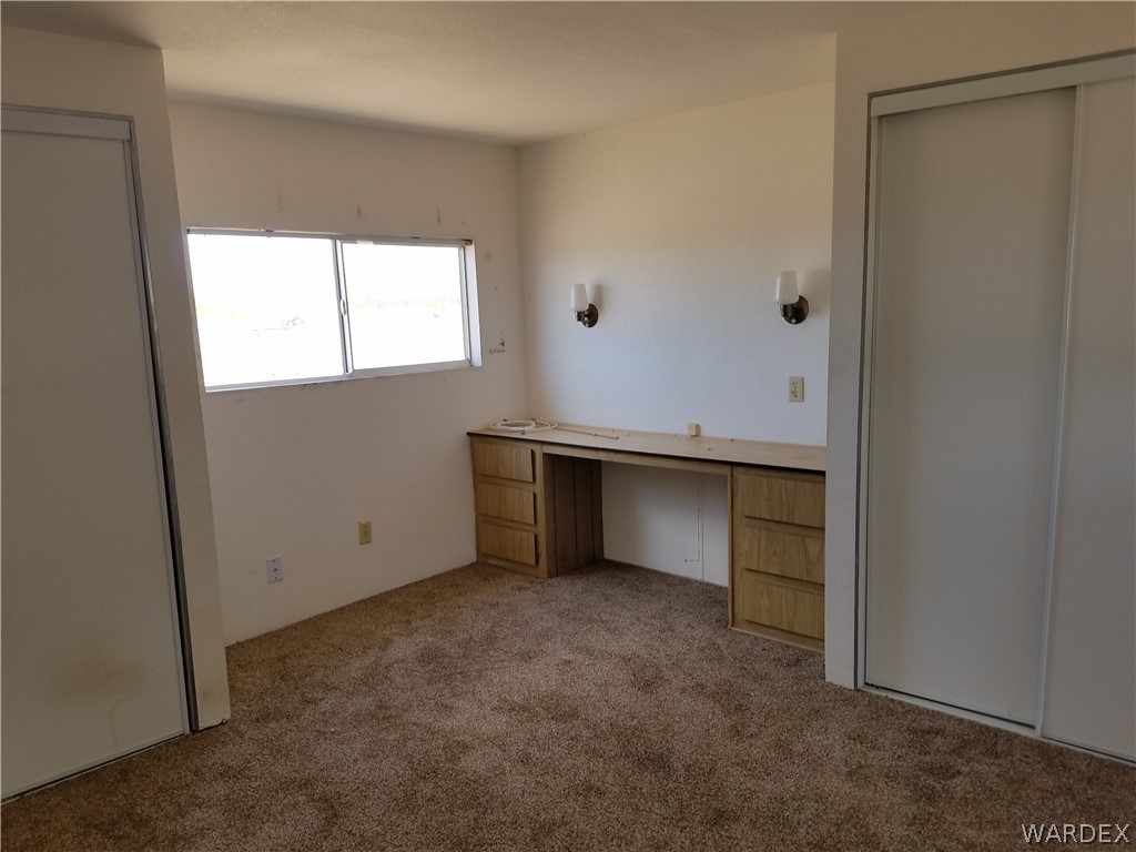 3645 Ligurta Road Golden Valley, AZ 86413 - Photo 5 of 17 Bedroom with built in desk area, double closets and new carpet