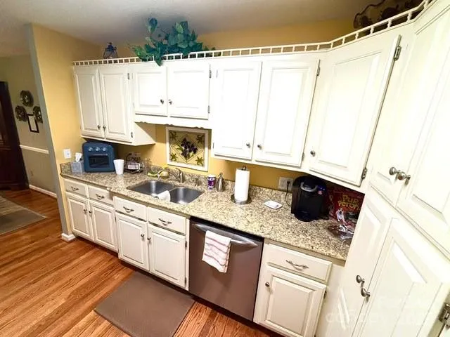 a kitchen with granite countertop a sink a stove and cabinets