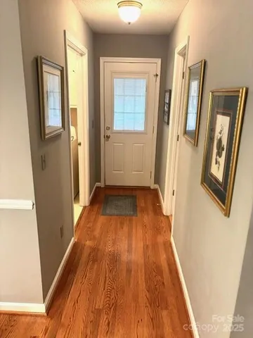 a view of a hallway with wooden floor and staircase