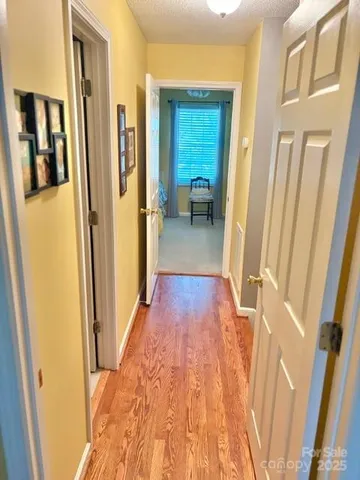 a view of a hallway with wooden floor and furniture