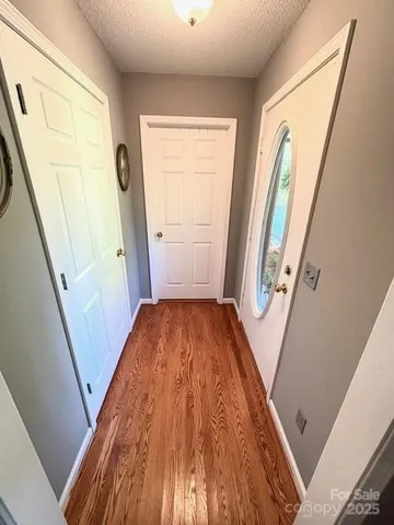 a view of a hallway with wooden floor and stairs