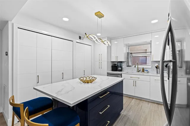 a kitchen with kitchen island a stove and a refrigerator