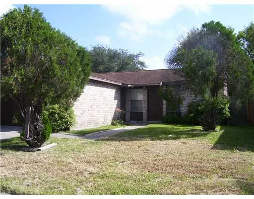 a view of a house with a yard and large tree