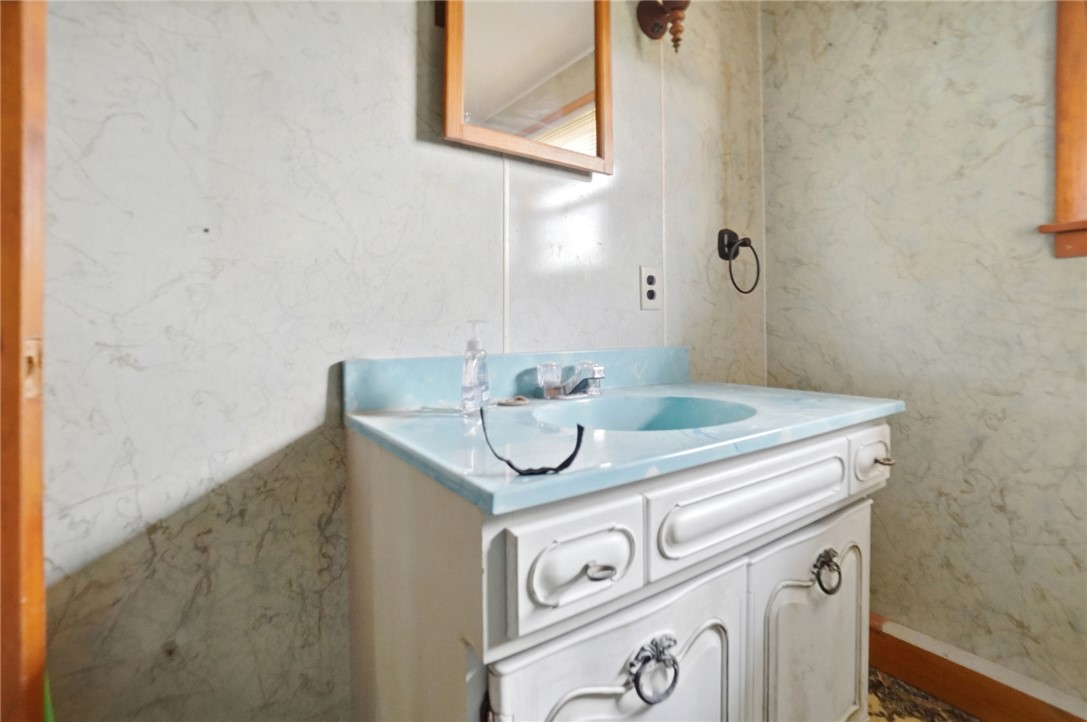 9750 Middlepoint Road Middle Point, OH 45863 - Photo 21 of 43 This bathroom features a single vanity with a blue countertop, a faucet, and a mirror.