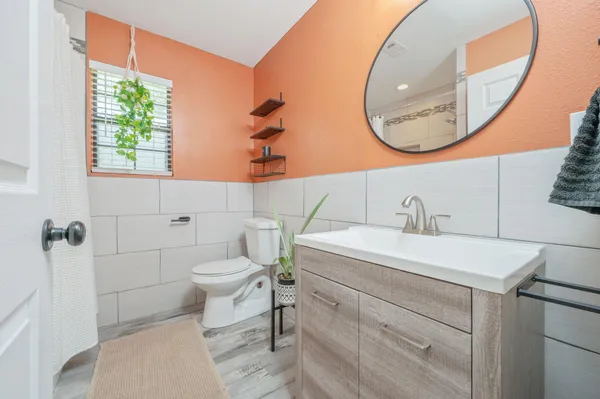 a bathroom with a sink a toilet and a mirror
