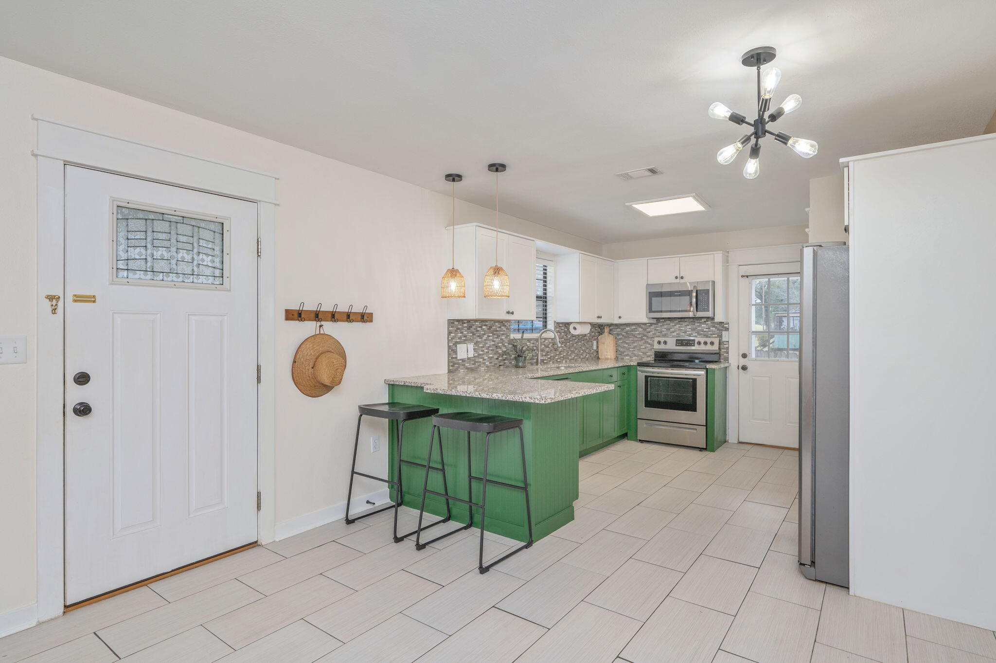 5816 Jack Stokes Road Baker, FL 32531 - Photo 5 of 16 a kitchen with kitchen island granite countertop a refrigerator a stove a sink dishwasher and white cabinets with wooden floor