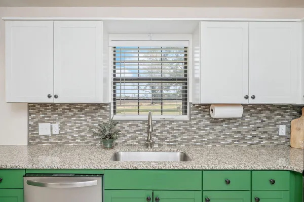 a view of kitchen with granite countertop window and sink