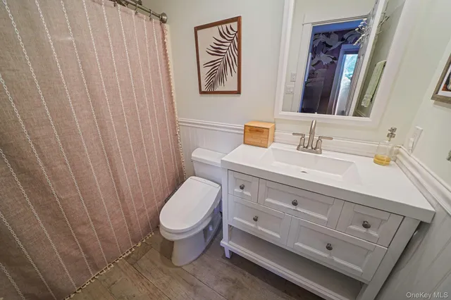a bathroom with a sink a toilet and a mirror