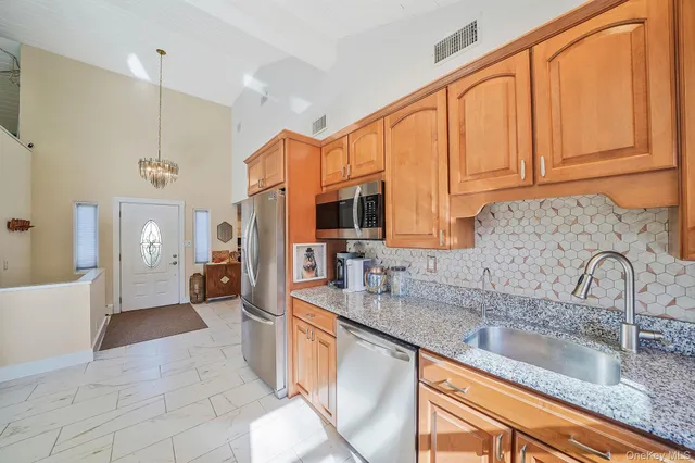a large kitchen with granite countertop a sink and cabinets