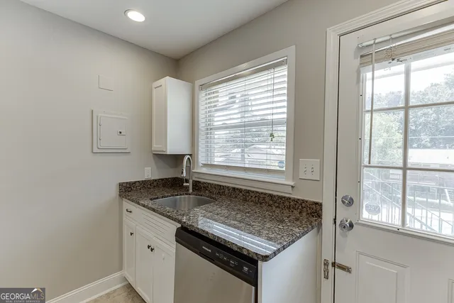 a kitchen with granite countertop a stove a sink and a microwave