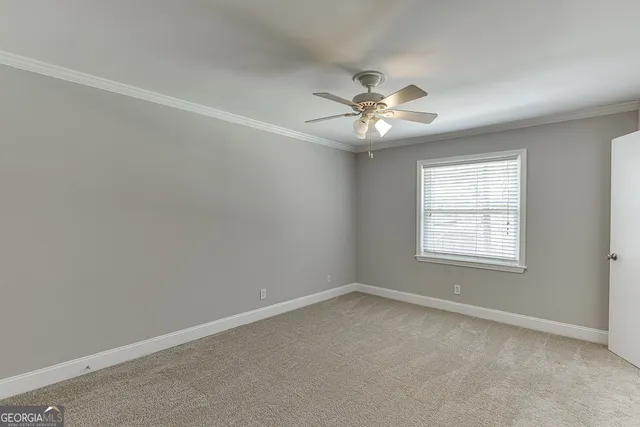 a view of an empty room and a ceiling fan