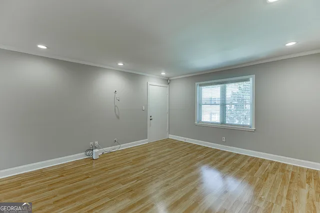 a view of empty room with wooden floor