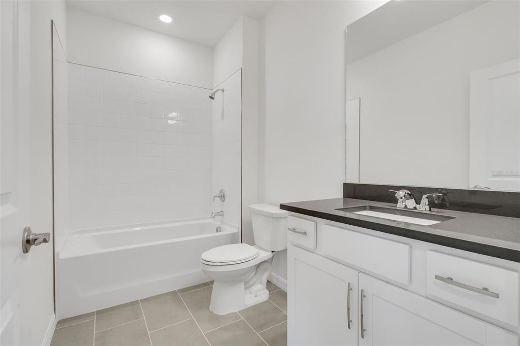 17024 Cottontail Circle Punta Gorda, FL 33982 - Photo 31 of 43 a bathroom with a granite countertop sink a toilet and a bathtub