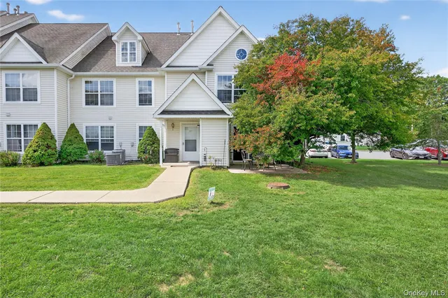 a view of a house with a big yard plants and large trees