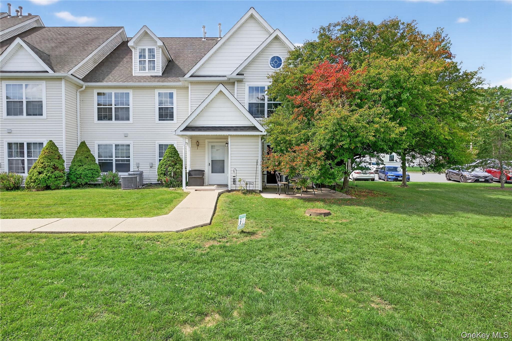 a view of a house with a big yard plants and large trees