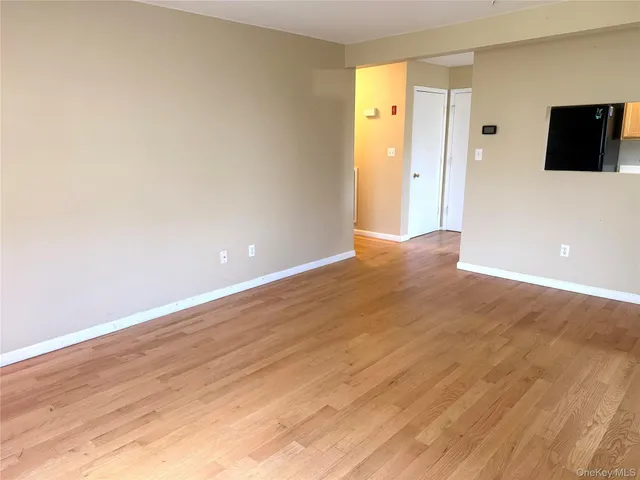 a view of a livingroom with wooden floor and a flat screen tv