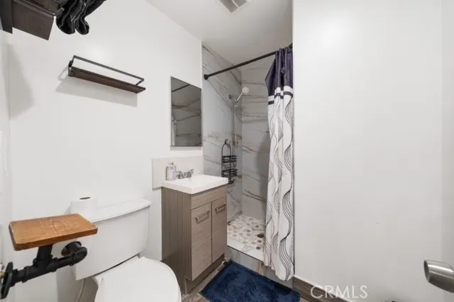 a bathroom with a granite countertop sink mirror vanity and toilet
