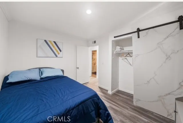 a bedroom with a bed and a painting on the wall