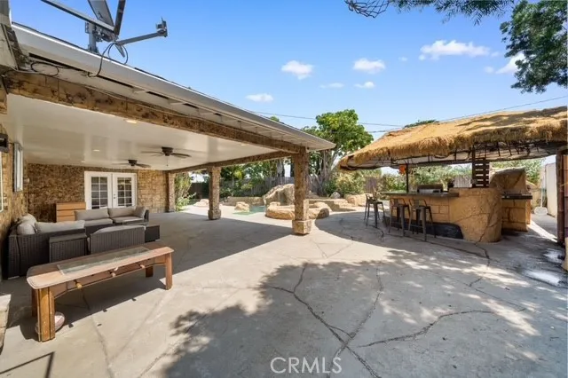 a view of a patio with dining table and chairs under an umbrella with a patio