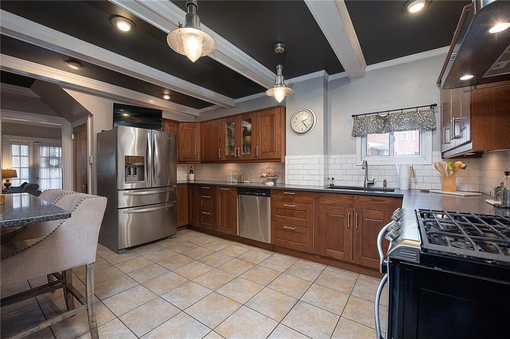 608 Blackburn Road Sewickley, PA 15143 - Photo 12 of 24 Craftsman wood cabinets, granite counters, white subway tile backsplash and beamed ceiling highlight this kitchen.